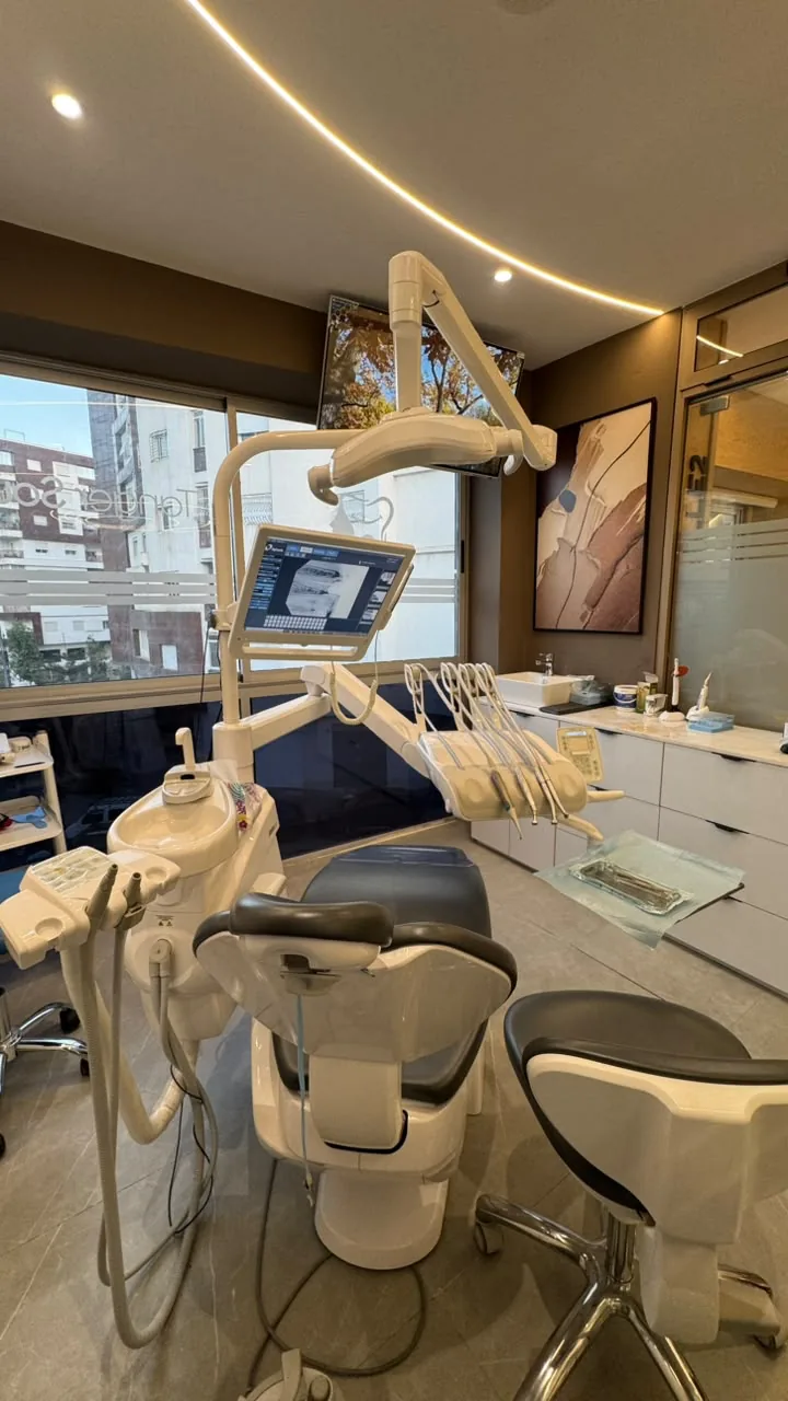 Fauteuil dentaire et écran de radiographie face à la baie vitrée